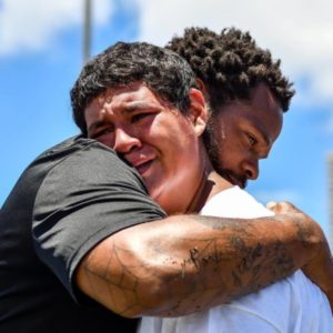 Michael Bennett and 2017 OCEAN Hawaii participant and 8th grader, Nathan Kekahuna II from Waialua, share a hug